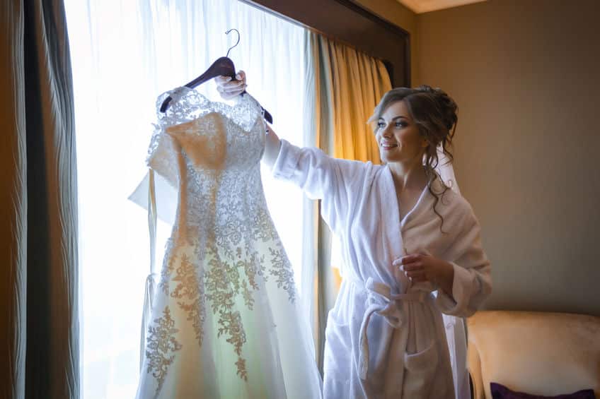 Noiva olhando para o vestido no making off